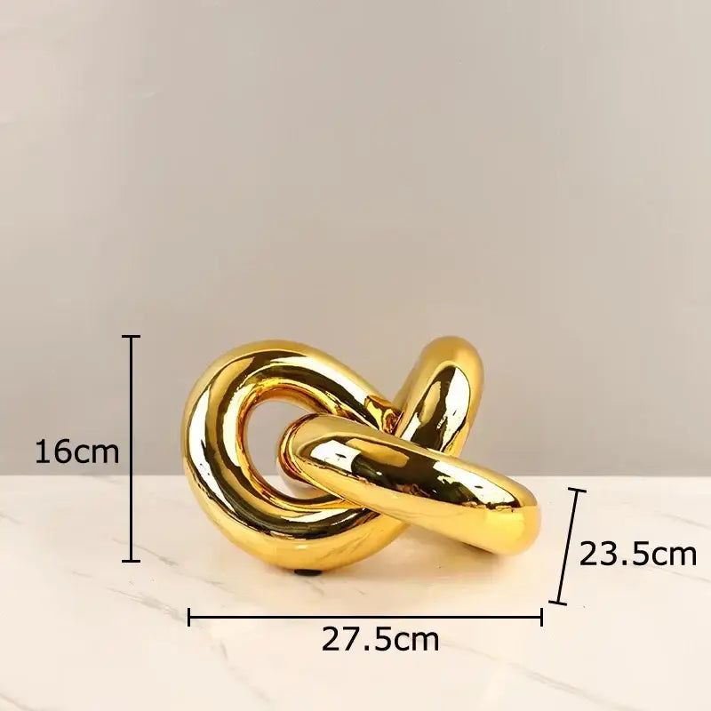 Modern gold-plated knot ornaments featuring a golden glossy metal sculpture with smooth interlocking loops for living room decorbites decor