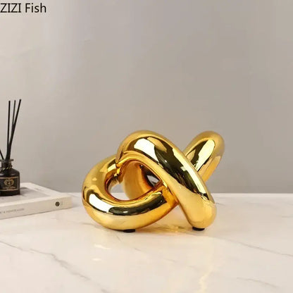 Modern gold-plated knot ornaments featuring a shiny gold ceramic knot sculpture with smooth reflective surfaces for decorbites gold-plated knot decor