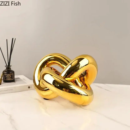 Modern gold-plated knot ornaments featuring a shiny gold ceramic knot sculpture with smooth reflective surfaces for decorbites gold-plated knot decor