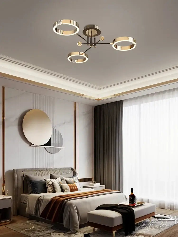 Modern gold plated luxury chandelier with three circular rings and central metallic hub for living room decorbites gold plated