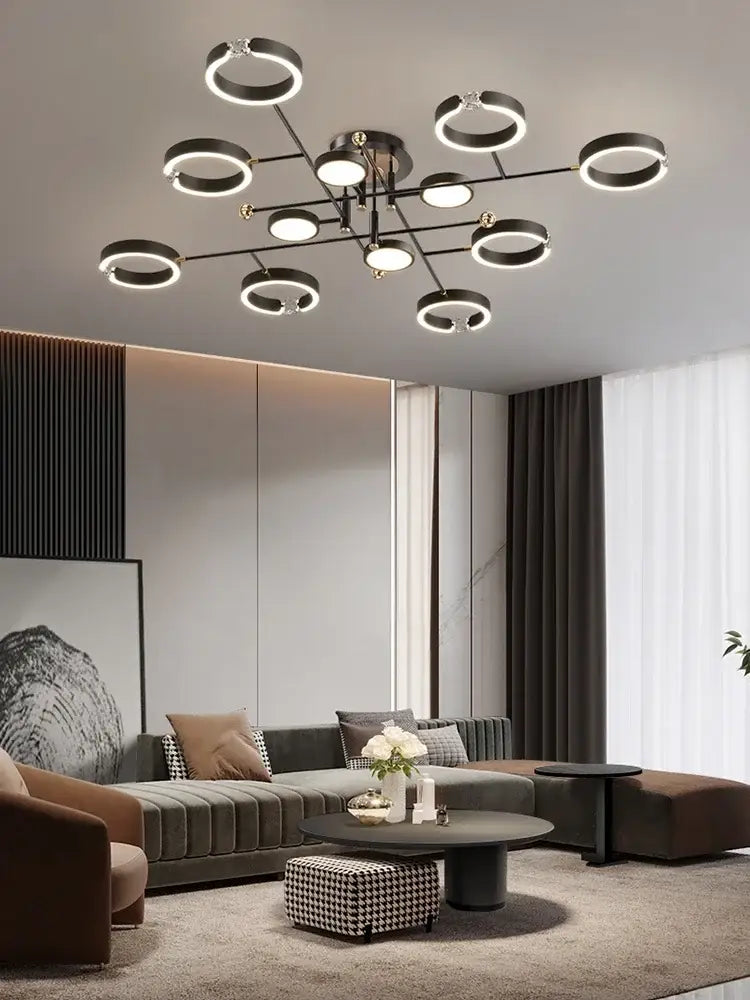 Modern black circular plated luxury chandelier with glowing ring lights and central metallic fixture for living room decorbites gold plated