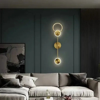 Modern gold plated wall lamp with three circular LED discs stacked vertically for elegant bedroom lighting decorbites gold plated
