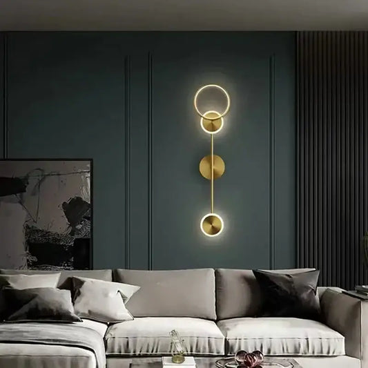 Modern gold plated wall lamp with three circular LED discs stacked vertically for elegant bedroom lighting decorbites gold plated