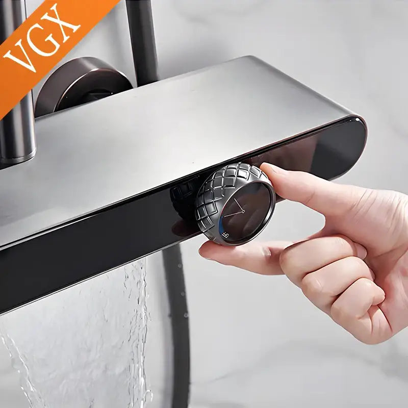 A sleek matte black bathroom faucet with a textured knob paired with a modern gold rainfall shower set