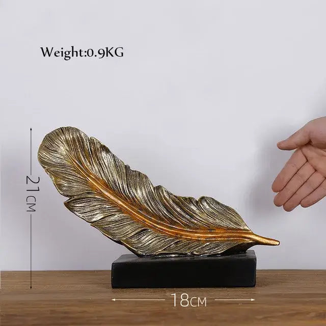 Modern gold resin sculpture with intricate golden feather design on black base by decorbites gold resin decorbites gold