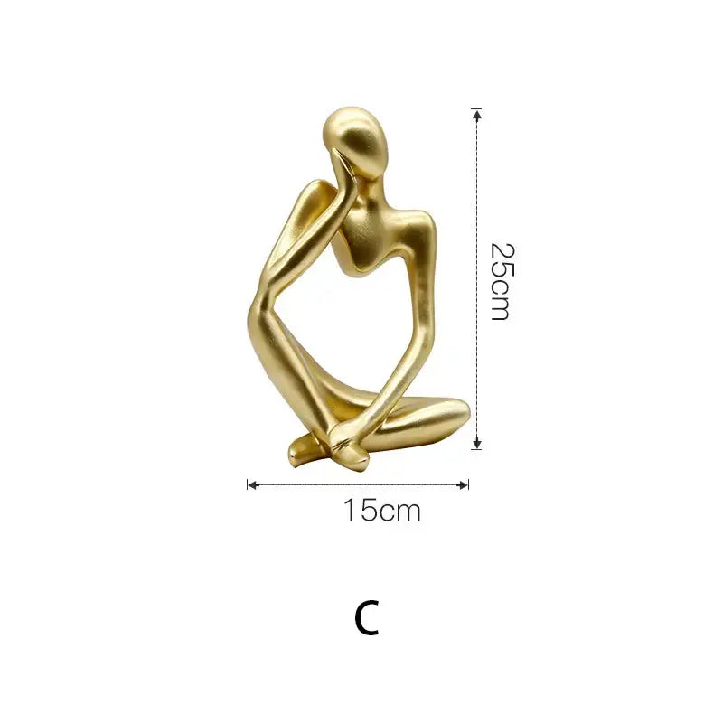 Modern gold resin sculpture of a seated contemplative human form with smooth abstract contours by decorbites gold resin
