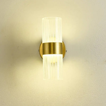 A modern gold wall lamp with clear ribbed glass shade luxury designed for bedroom bedside use