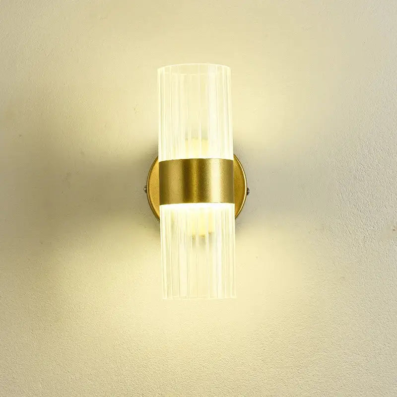 A modern gold wall lamp with clear ribbed glass shade luxury designed for bedroom bedside use
