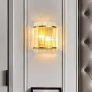 Modern gold ribbed glass living room wall mount light with vertical crystal rods and warm glowing light