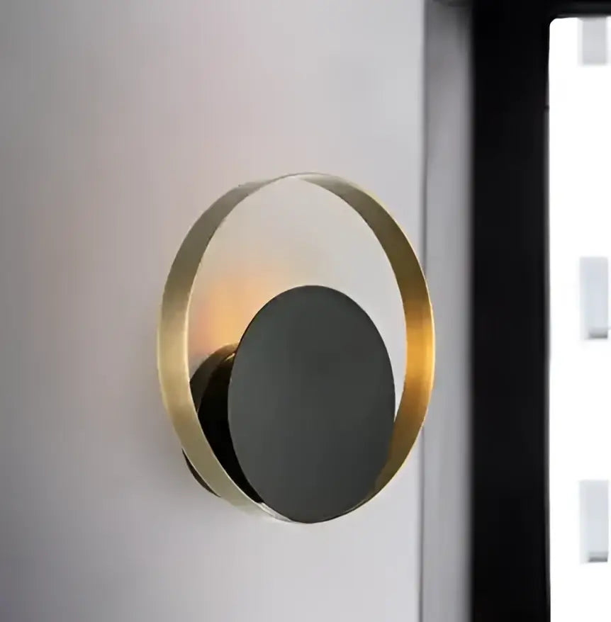 A modern gold ring ball g4 round wall lamp with a black matte disc emitting warm light for bedroom decorbites glass ball