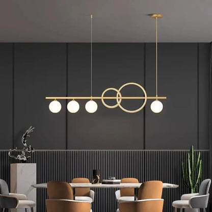Modern gold-toned pendant light with five spherical bulbs and intersecting rings for elegant chandelier dining decorbites use