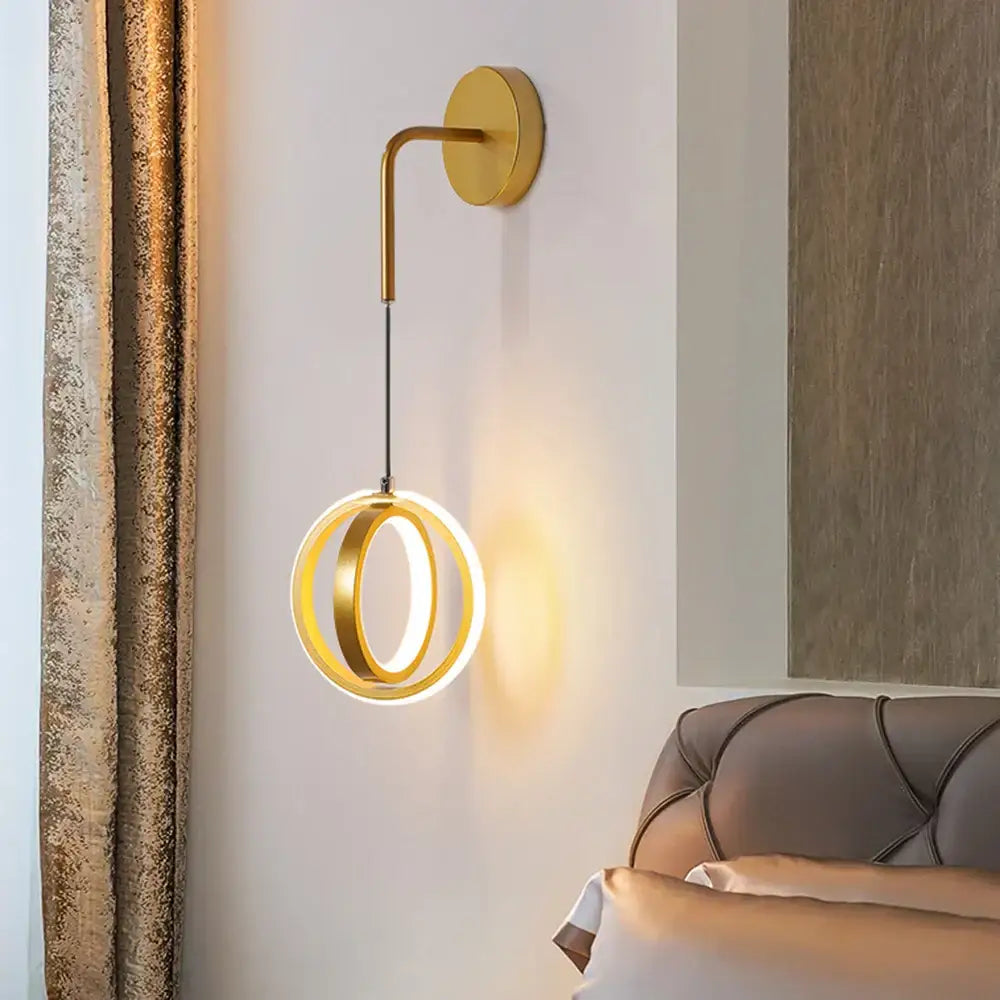 Modern gold ring led wall lamp with two concentric circular rings emitting warm glow for bedroom and living room