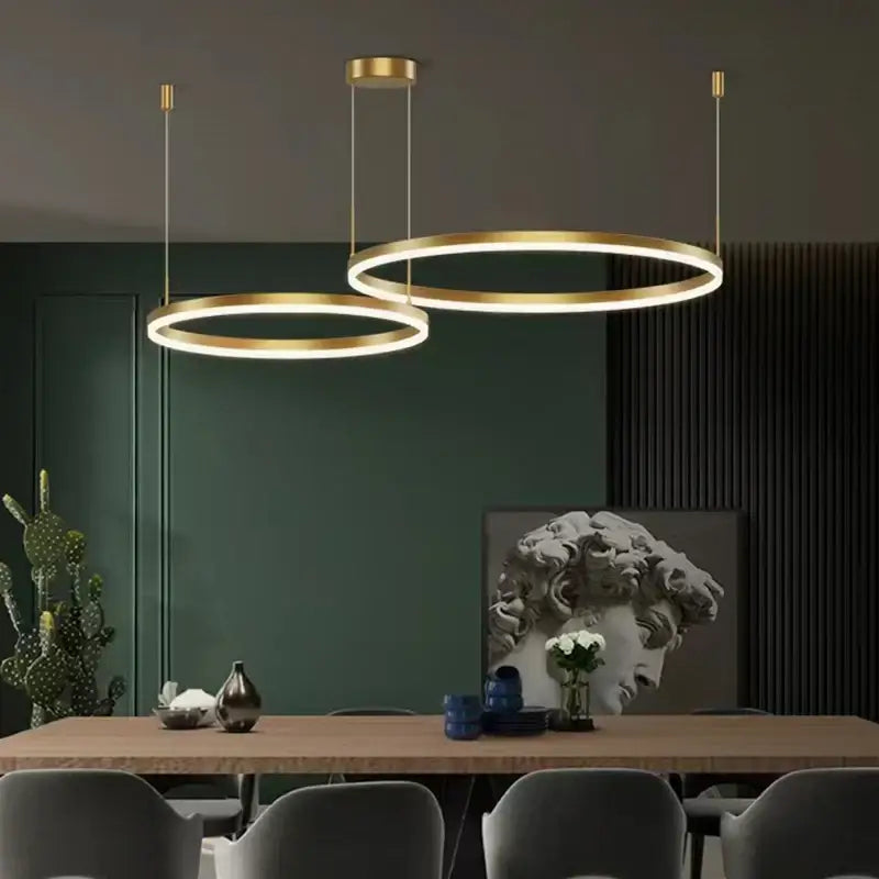 Two modern gold ring pendant ceiling lamps with sleek circular LED decorbites gold ring design for dining room decor