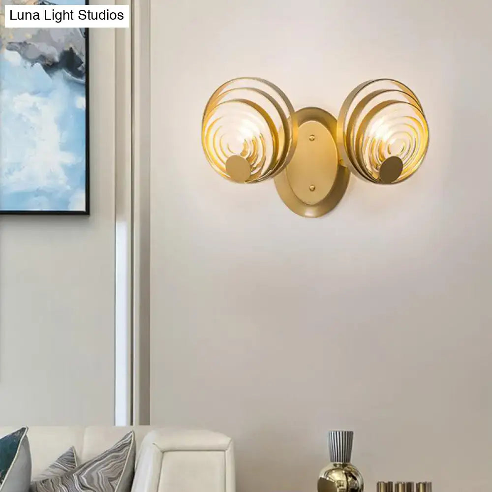 Modern gold wall light featuring two circular ripple glass shades as a stylish living room light fixture