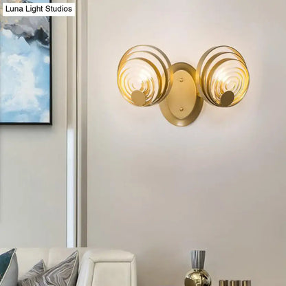 Modern gold wall light featuring two circular ripple glass shades as a stylish living room light fixture