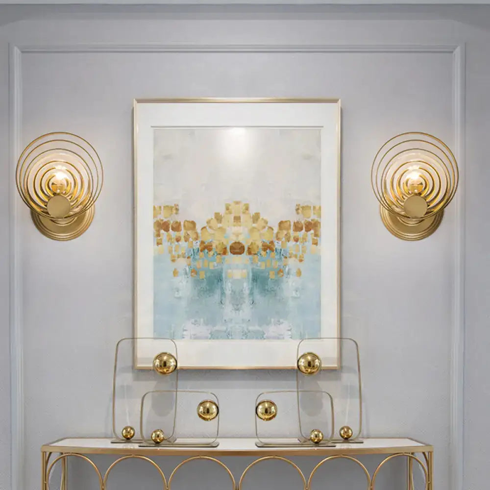 Modern gold ripple glass wall light fixture featuring gold-toned concentric circles for living room use