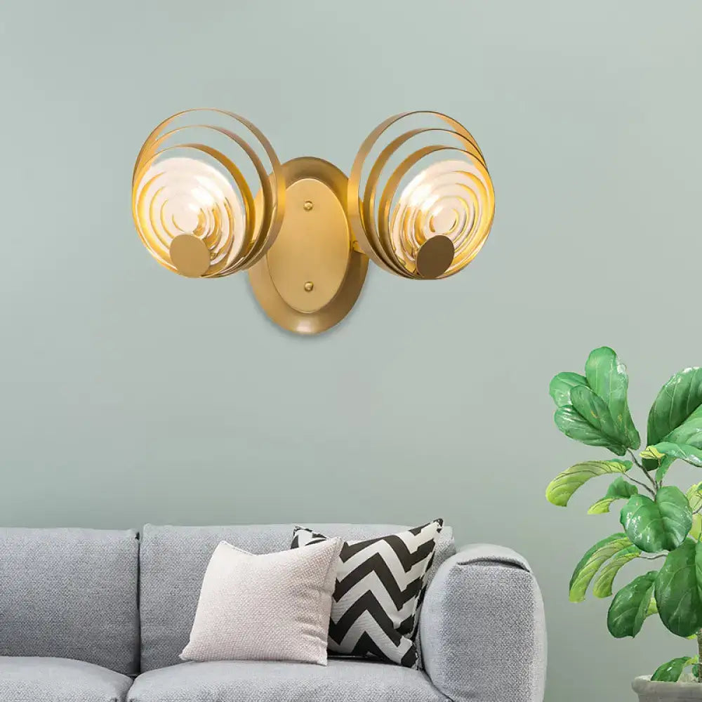Gold-toned wall light fixture with two spiral ripple glass shades ideal for modern living room lighting