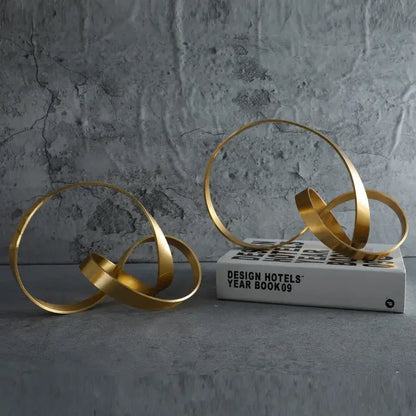Modern gold rope knot metal sculpture with interlocking circular bands for home decor decorbites gold rope design