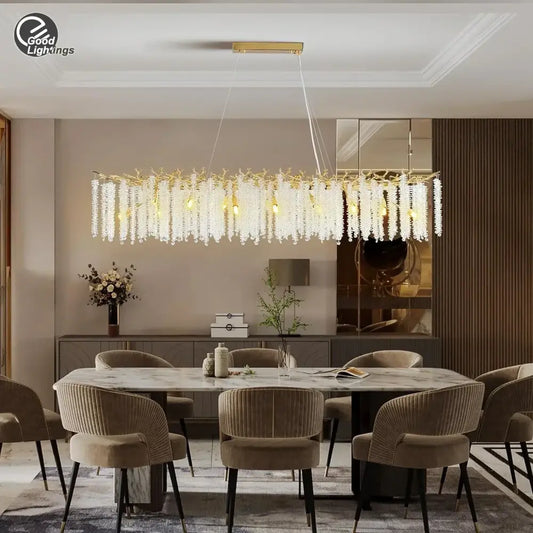 A modern decorbites gold round chandelier with cascading white crystal droplets and a rectangular gold frame for dining room light