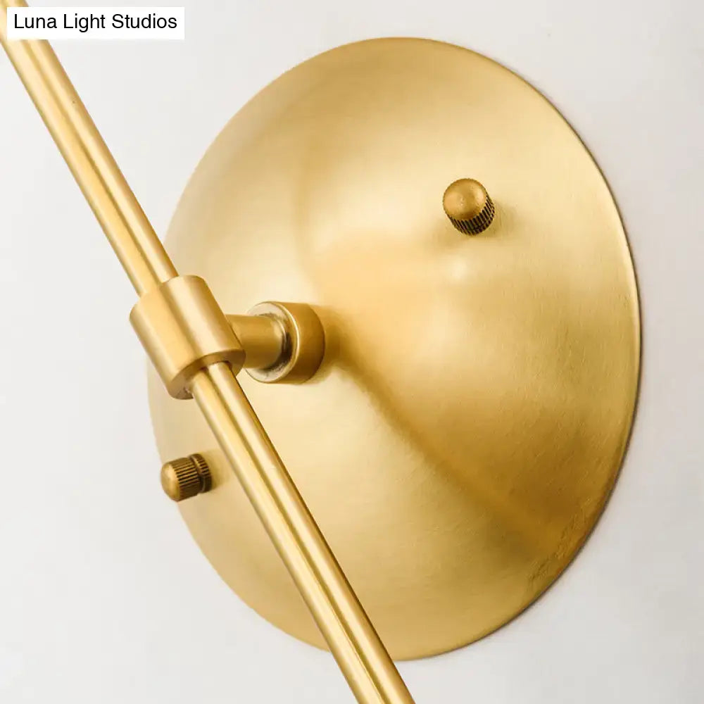Brass-finished modern gold round wall lamp with opal glass and angled arm for bedroom lighting