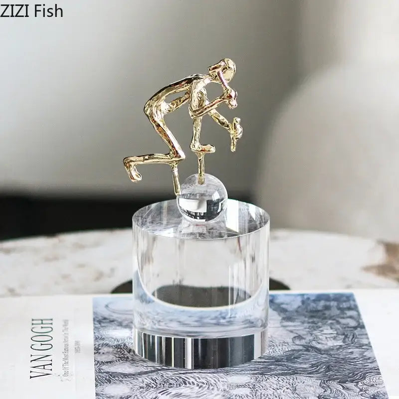 Modern gold runner crystal sculpture features a gold-toned abstract figurine on a clear crystal base for decorbites crystal sculpture decor