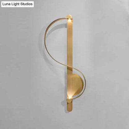 Modern gold s-shape wall lighting fixture with sleek curved metal design and warm ambient lighting for living room corner