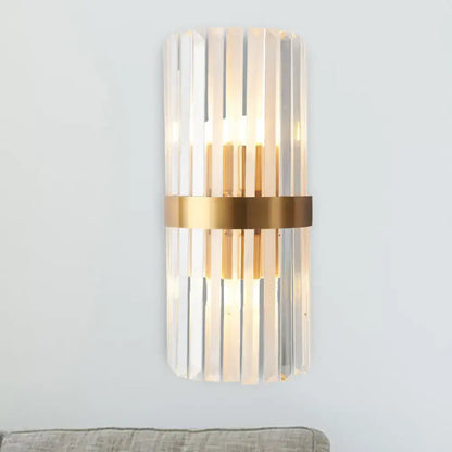 Modern gold sconce light with vertical crystal rods and metallic band designed as a wall lamp for bedroom use