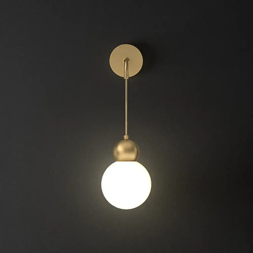 Modern gold sconce light wall lamp with milky glass globe and minimalist metal fixture for bedroom use