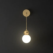 Modern gold sconce light wall lamp featuring a gold-toned spherical pendant with milky glass and minimalist fixture