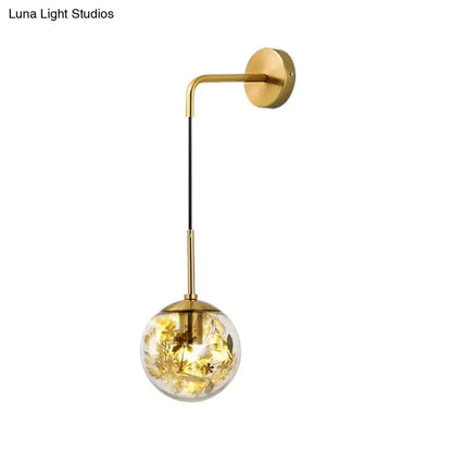 Modern gold shattered leaf clear glass globe sconce light fixture with gold-toned spherical glass containing leaf accents