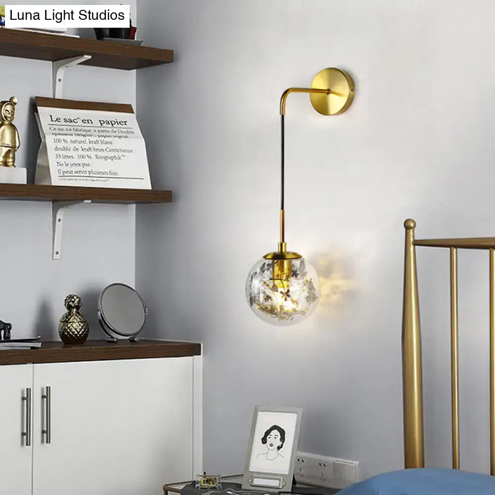 Modern gold shattered leaf clear glass globe sconce light fixture with spherical globe and illuminated interior for bedroom use