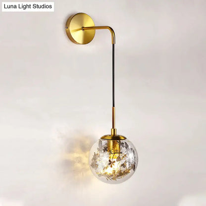 Modern gold shattered leaf clear glass globe sconce with floral etchings and black stem for bedroom light fixture