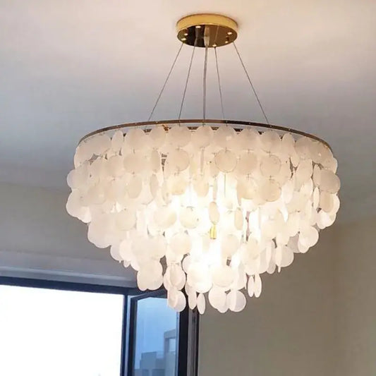 A modern gold shell chandelier with layered white shell-like discs and gold-toned ceiling mount for living room decorbites gold shell