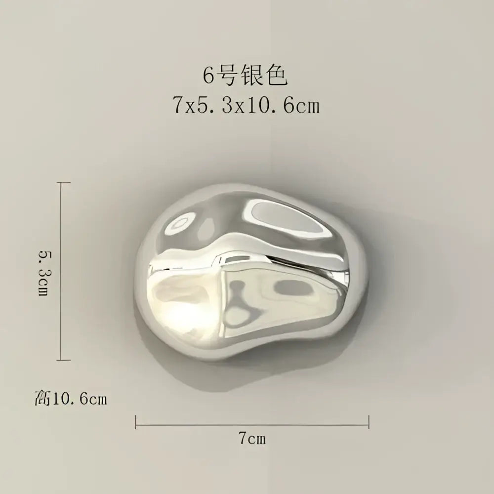 A sleek silver metallic 3d stone wall ornament with a smooth rounded form for modern living room decor