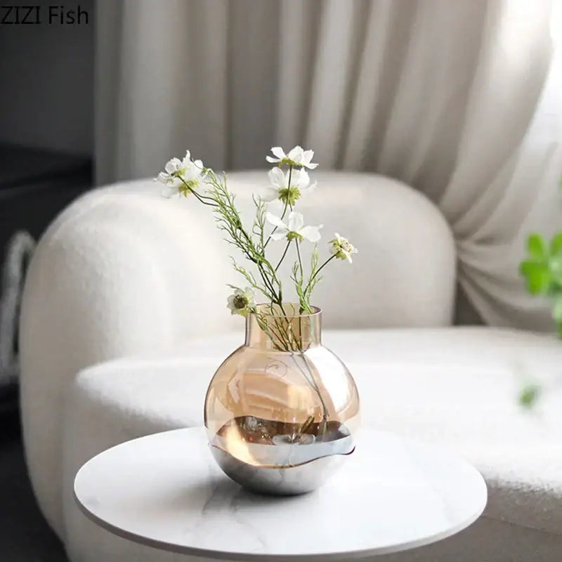 A sleek decorbites amber glass vase with a metallic base and white flowers for modern living room decor