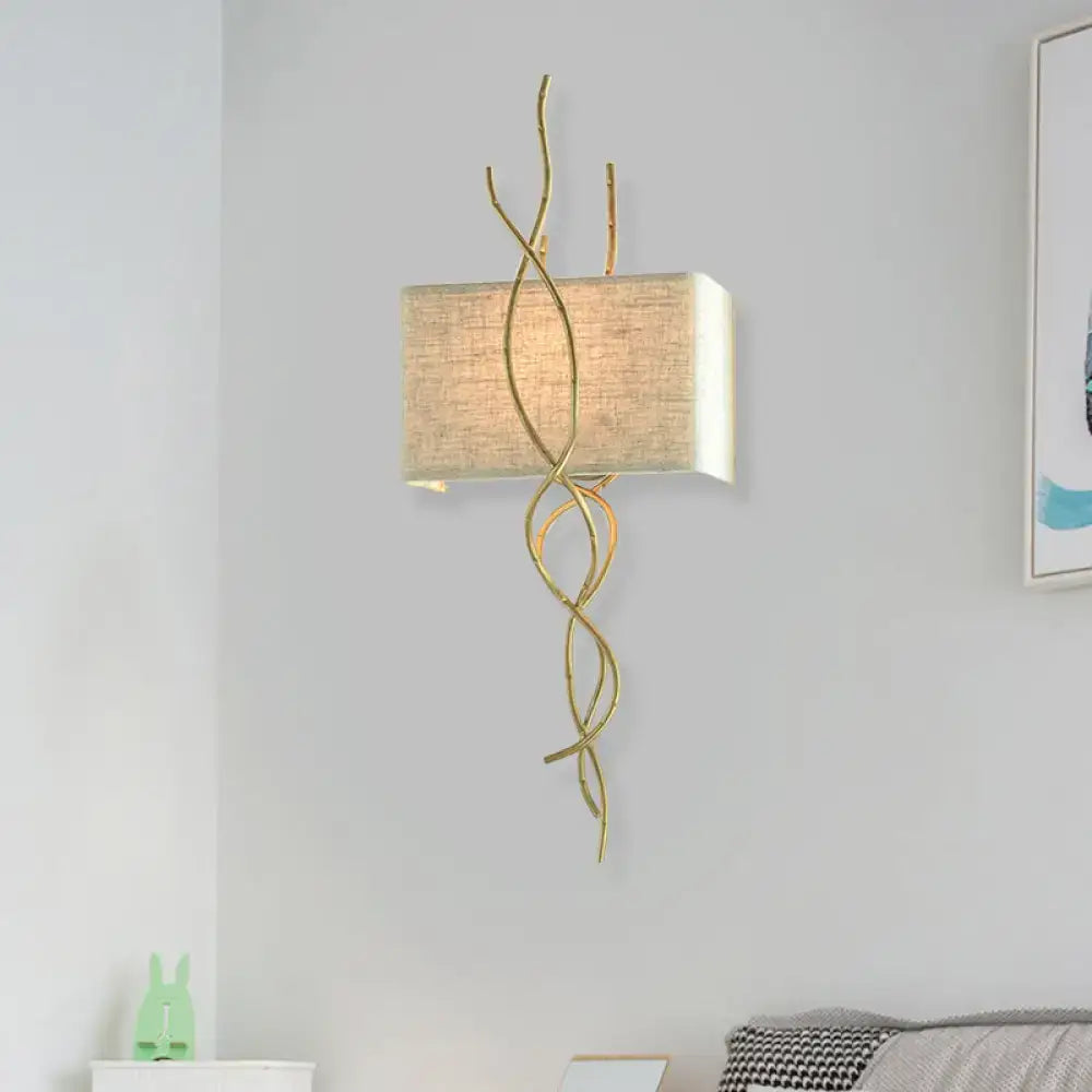 Modern gold wall mount light with gold-toned wrought iron and beige linen shade for bedroom use