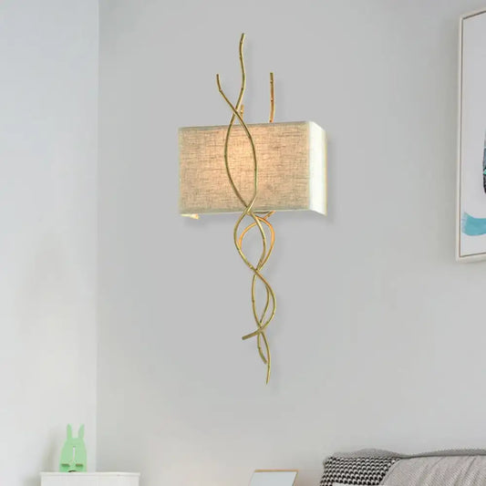 Modern gold wall mount light with gold-toned wrought iron and beige linen shade for bedroom use