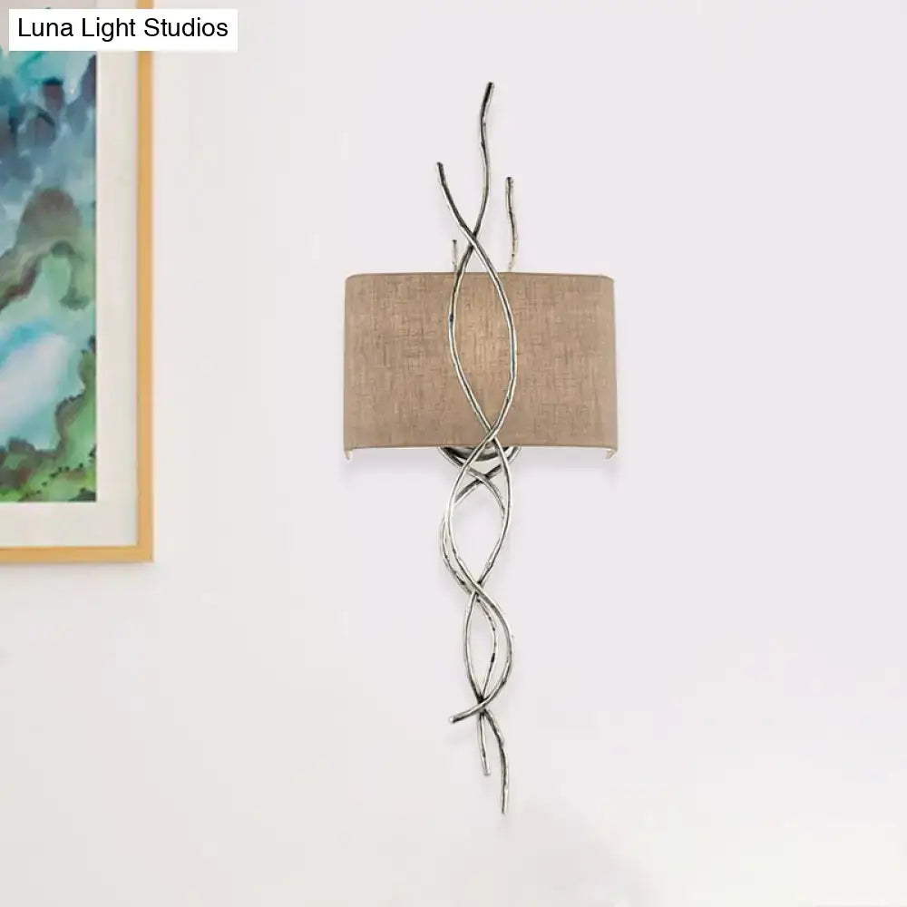 Silver twisted wire wall mount light with a beige fabric shade in a modern gold silver branch design for bedrooms