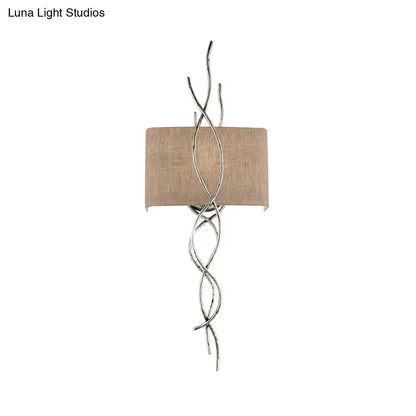 Silver twisted wire wall mount light with beige fabric shade in modern gold silver branch bedroom sconce design