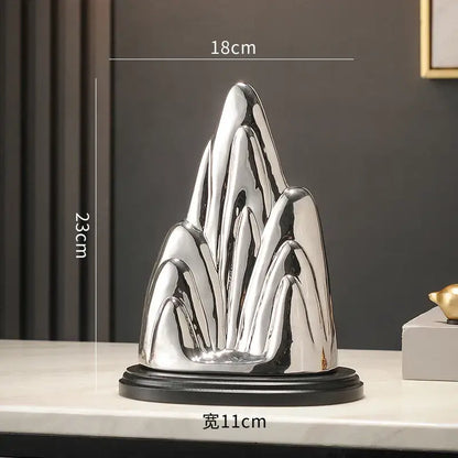 Shiny silver ceramic mountain sculpture with sleek modern design on black base for decorbites ceramic mountain decor