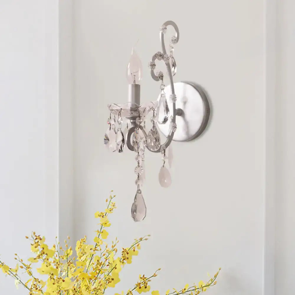 Silver-toned crystal drop sconce light with dangling teardrop crystals and ornate metal frame for living room decor