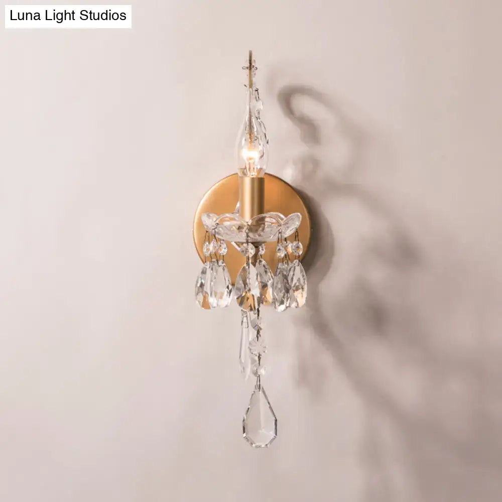 Modern gold and silver crystal drop sconce light with clear crystal droplets and faceted prisms for living room decor