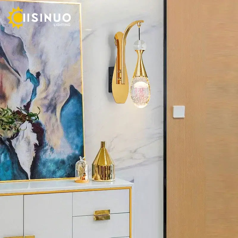 Modern gold and silver crystal led wall sconce with gold-toned curved arm and teardrop decorbites crystal led pendant