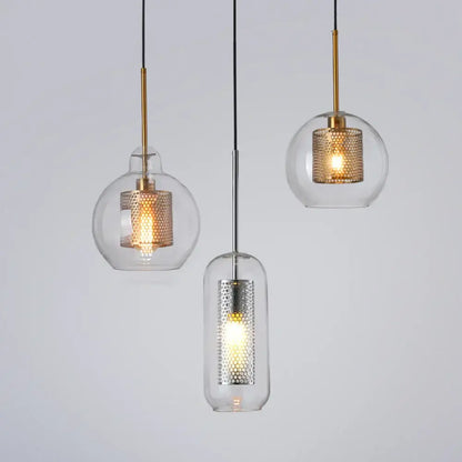 Three modern pendant lights with clear glass shades and gold and silver honeycomb metal inserts for kitchen use