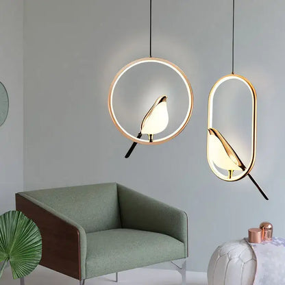 Two modern pendant lights with golden bird silhouettes and led bulbs in metallic finish for dining room use