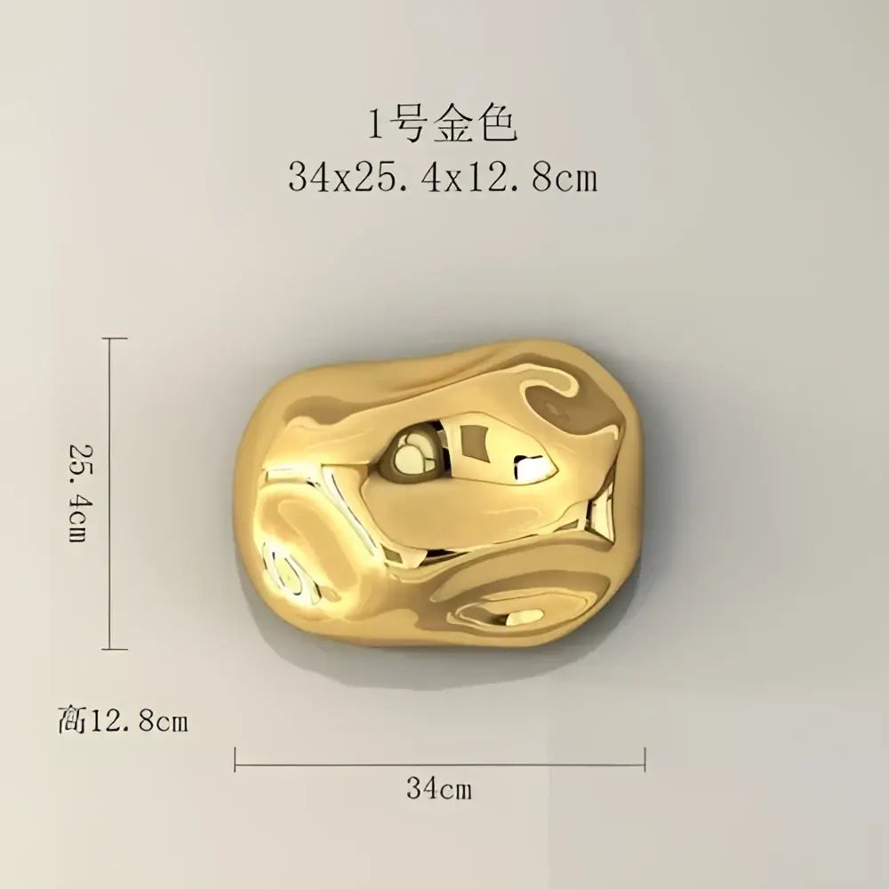 A polished gold-colored metal wall hanging ornament with abstract irregular contours for modern living rooms