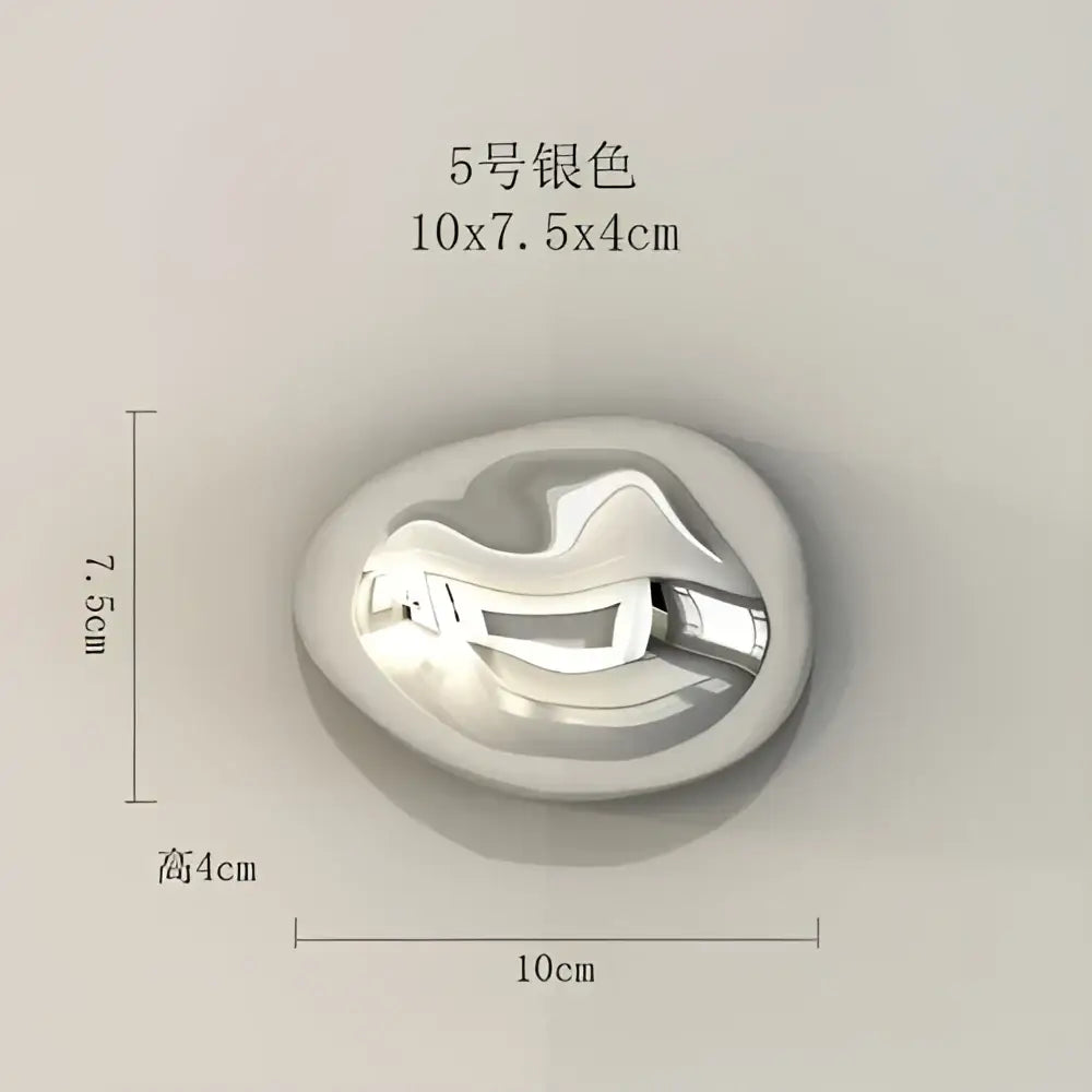 Silver-colored oval pendant with smooth reflective metallic finish and abstract wave design wall hanging ornaments