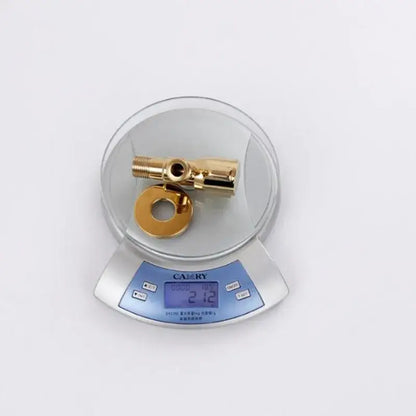 Modern gold solid brass triangle valve and washer for bathroom faucet fixture resting on digital scale