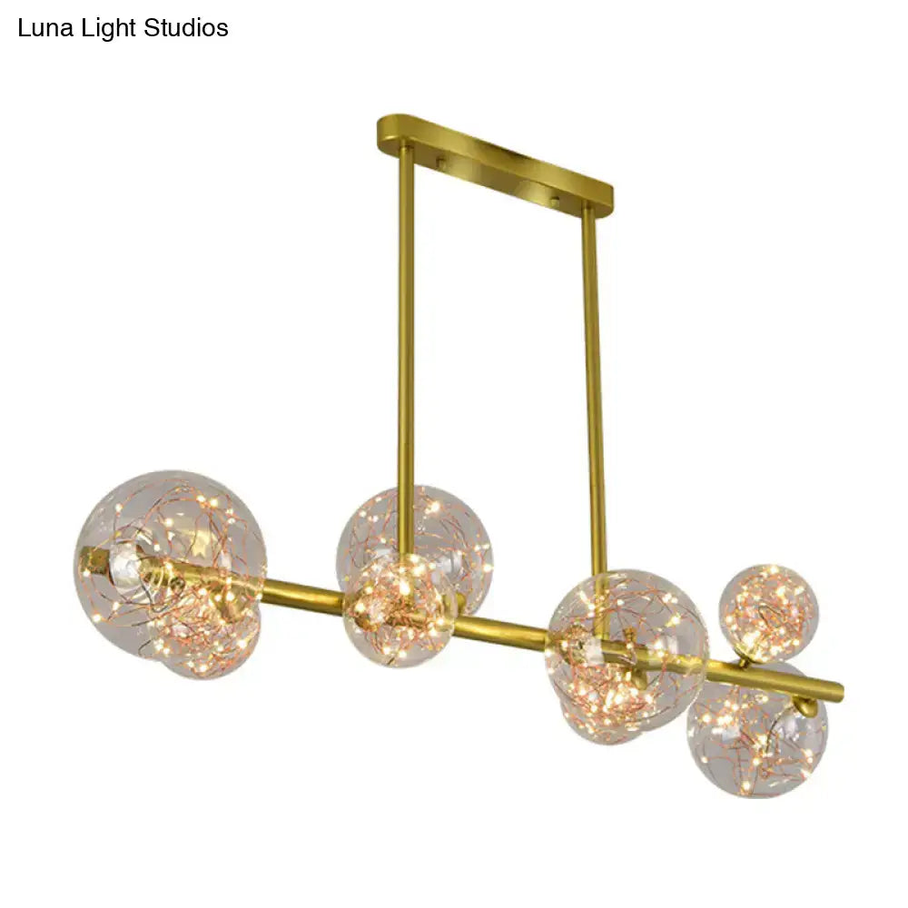 Modern gold spherical clear glass chandelier light fixture with clear glass spheres and warm fairy lights for dining room