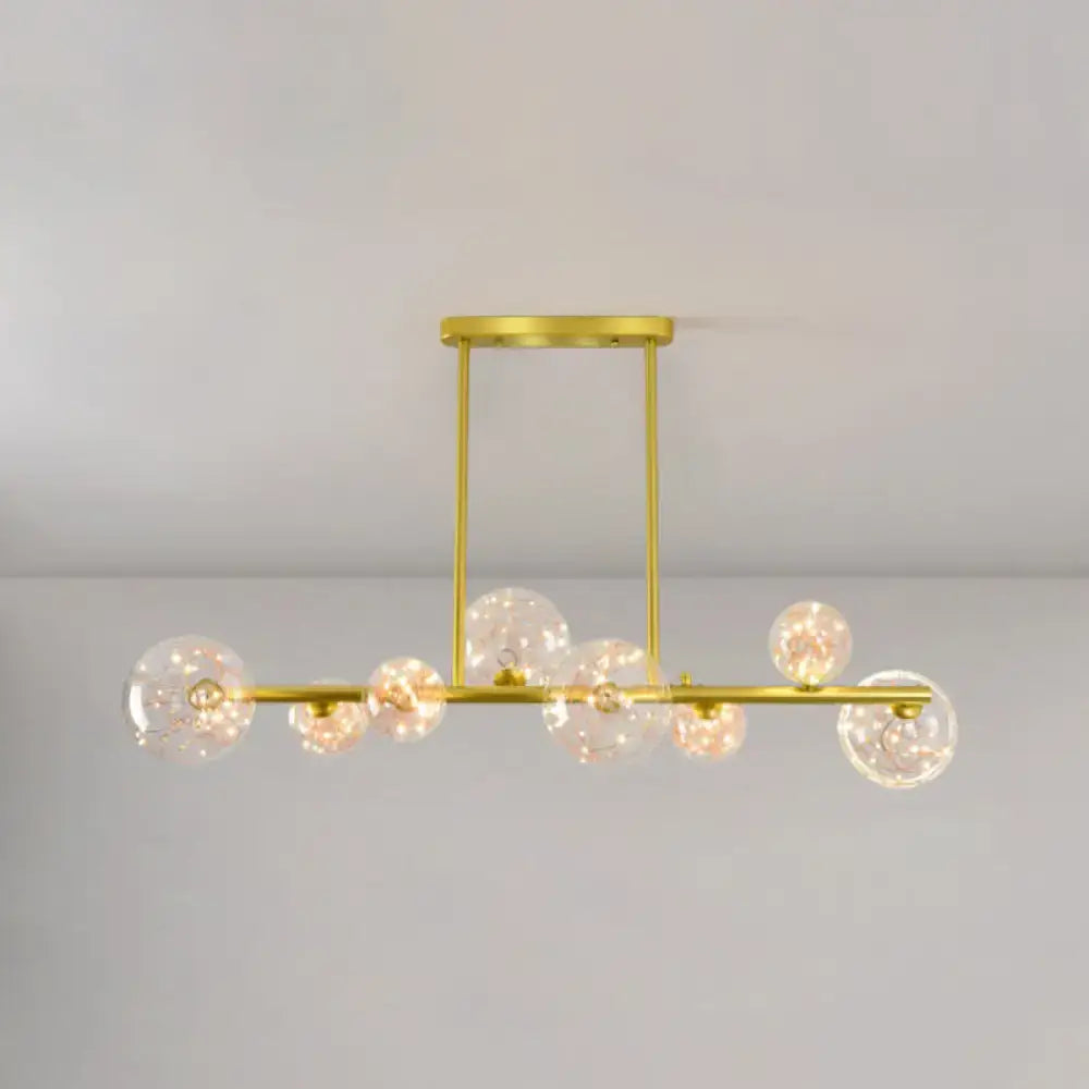 Modern gold spherical clear glass chandelier light fixture featuring gold-toned metal and clear glass globe bulbs